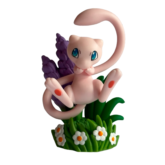 A small pink cartoon creature with large blue eyes sits among green grass, white flowers, and purple plants against a patterned background—perfect for fans of The Pokémon Company’s Pokémon TCG: 30th Celebration Figure Collection or as a display piece alongside your favorite collectibles.