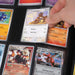 A hand holds a Kangaskhan Pokémon card above a Gemloader: Premium Samlekortmappe [1024 pockets 4X4] with organized Pokémon cards, such as Scizor and Heatran LV.X, all securely stored in protective sleeves by Gemloader.